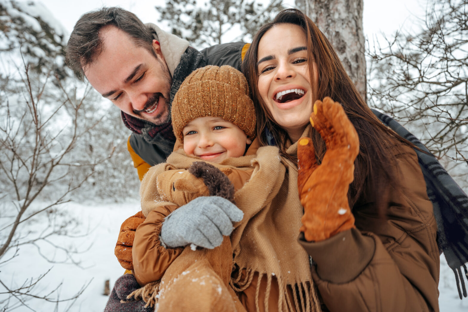 Family enjoying light snow in the transition from fall to winter.